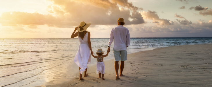 Family walking on Florida beach at sunset