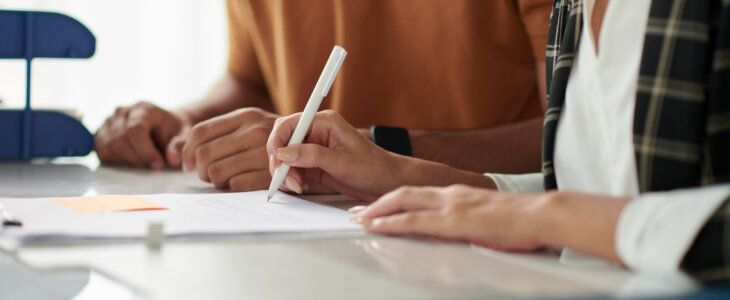 Two people reviewing and signing a document