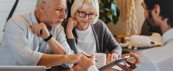 Financial advisor explaining paperwork to elderly retired couple