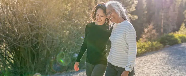 a younger woman walking next to an older woman while both smiling