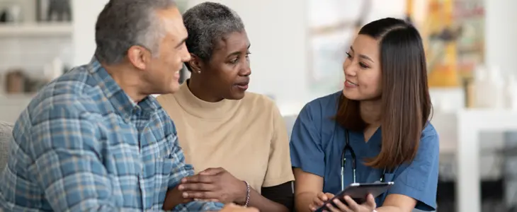 a man and woman speaking with a female medical professional