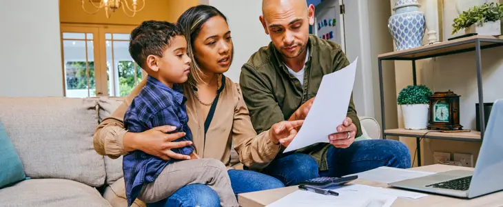 a young couple with son on lap reading over document