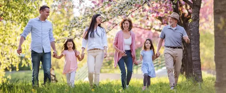 A large, 3-generation family taking a walk at a park