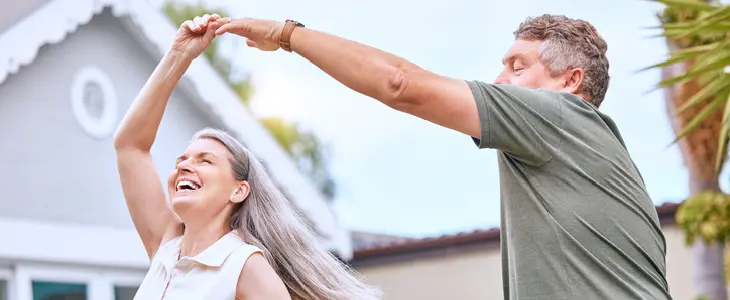 Retired couple standing outside of their home