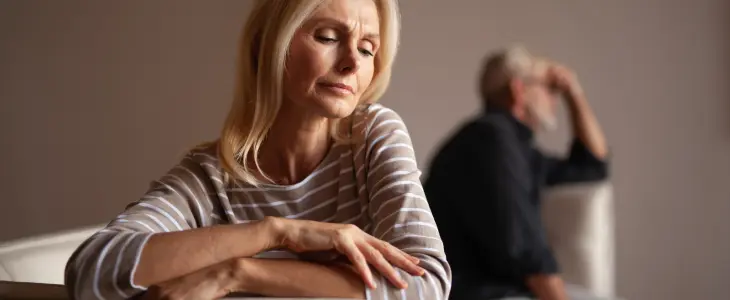 Sad woman in foreground with distraught man in background.